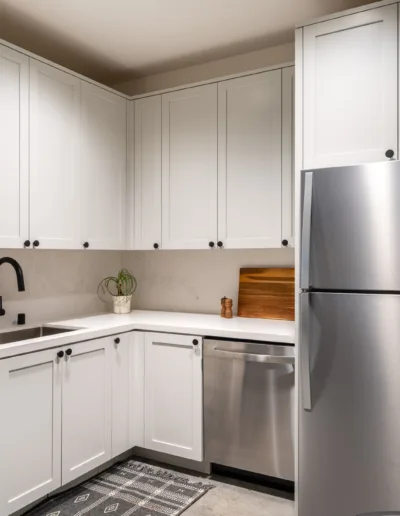 A kitchen with stainless steel appliances and white cabinets.